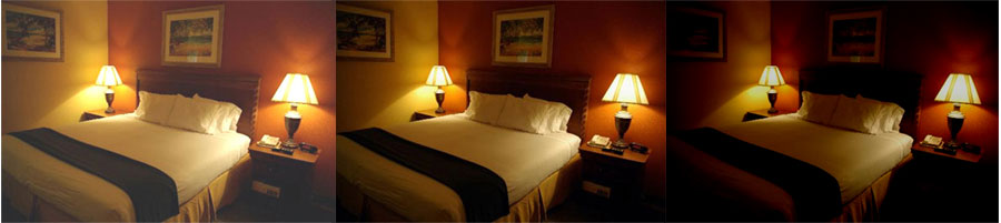 Esta imagem mostra três fotos idênticas de um quarto de hotel, lado a lado, com brilhos diferentes. O quarto tem uma cama de casal com lençóis brancos, duas luminárias acesas nos criados-mudos e uma parede vermelha ao fundo. Da esquerda para a direita, a luz vai ficando mais escura.
