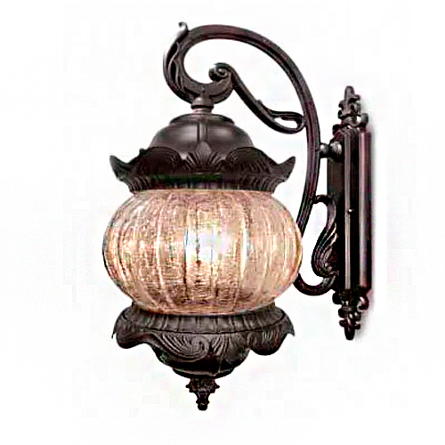 Uma arandela clássica de parede em metal bronze escuro. Possui suporte curvado e ornamentado que segura uma lanterna arredondada. O vidro é fosco e texturizado, envolto por detalhes metálicos que lembram pétalas ou uma coroa. Estilo elegante, ideal para áreas externas ou corredores.