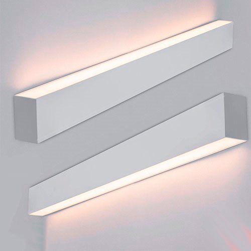 A imagem mostra duas luminárias de parede (arandelas) retangulares e minimalistas, fixadas horizontalmente em uma superfície clara. Elas possuem acabamento branco e emitem uma luz suave e indireta: a de cima projeta brilho para o teto e a de baixo para o chão, criando um efeito elegante.