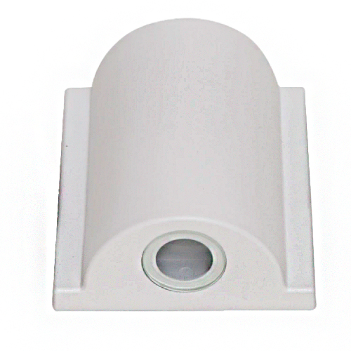 Esta arandela branca tem um design moderno e curvo. Fixada diretamente na parede, possui uma base retangular de onde sobressai uma cúpula em formato de meia cana vertical. Na parte inferior, há uma pequena lente circular por onde é projetado um único facho de luz focalizado.