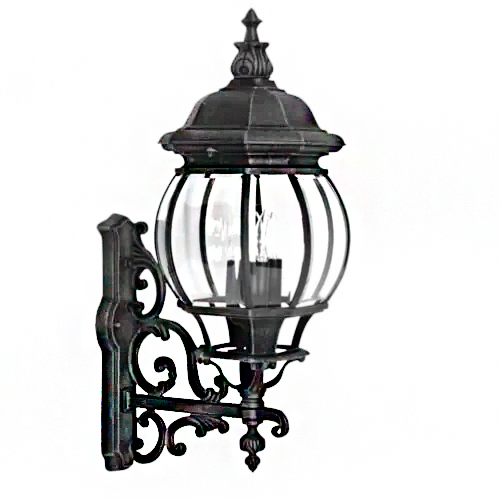 Luminária de parede clássica (arandela) em metal preto e vidro. Possui base trabalhada com arabescos elegantes, lembrando o estilo colonial. O globo é transparente e arredondado, protegido por hastes metálicas, com um topo em formato de chapéu pontiagudo e decorativo. Estilo retrô.