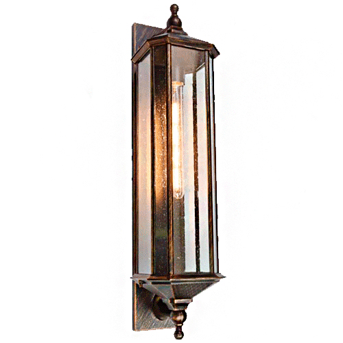 
Uma arandela externa de parede alta e estreita, em estilo clássico. Possui estrutura metálica em tom bronze envelhecido e vidros transparentes que revelam uma lâmpada de filamento longa e acesa no centro. O design é elegante, com acabamentos pontiagudos nas extremidades superior e inferior.