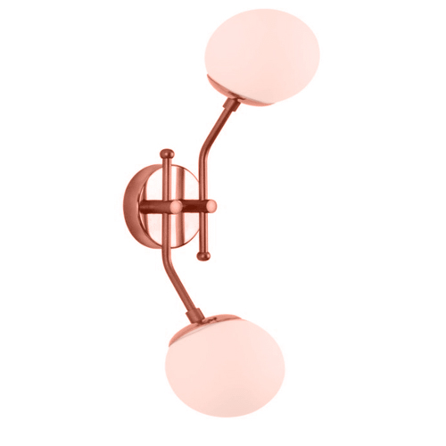 
Esta arandela em tom cobre possui um design dinâmico e elegante. De uma base circular de parede, partem duas hastes metálicas curvas em direções opostas: uma para cima e outra para baixo. Cada extremidade sustenta um globo esférico de vidro branco fosco, criando luz em níveis diferentes.