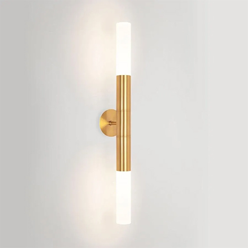 
Esta arandela dourada tem um design de tubo vertical longo e fino. O centro é de metal dourado escovado, e as duas extremidades são difusores cilíndricos brancos que brilham intensamente. Ela é fixada à parede por uma pequena base circular central, projetando luz para cima e para baixo.