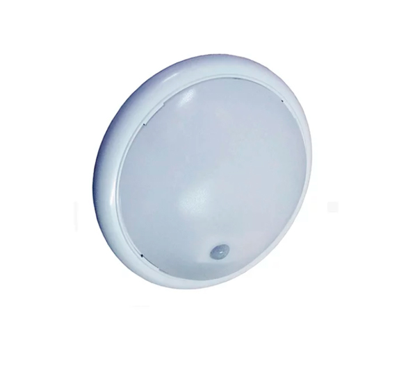 Essa é uma luminária de teto (plafon) branca e redonda, com uma tampa abaulada que difunde a luz. Ela possui um pequeno sensor preto embutido na parte inferior, indicando que é um modelo com sensor de presença. Isso significa que a luz acende automaticamente ao detectar movimento, sendo comum em corredores, escadas e garagens para economizar energia.