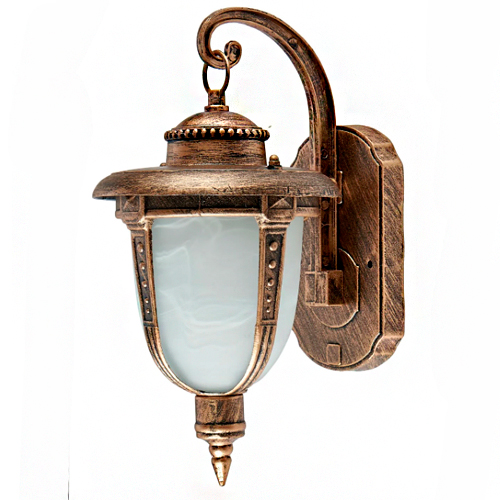 É uma arandela de parede para área externa, estilo clássico. Estrutura em metal dourado envelhecido com detalhes decorativos. Possui cúpula de vidro fosco esbranquiçado em formato de sino alongado. O braço é curvo, com base oval fixada na parede. Ilumina de forma suave e elegante