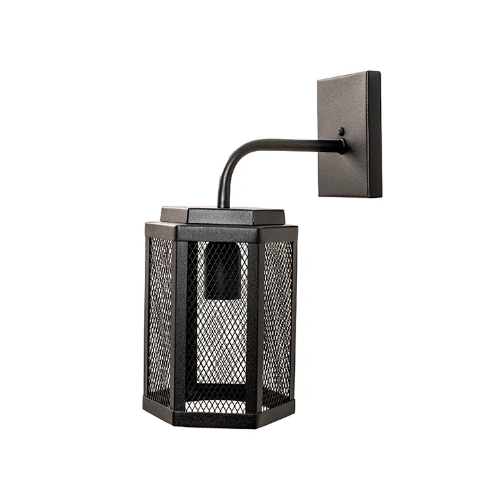 Esta arandela preta tem estilo industrial. Uma base quadrada fixa-se à parede, conectada por um braço curvo a uma lanterna hexagonal pendente. O corpo da luminária é feito de uma tela metálica fina que deixa a lâmpada visível, criando uma iluminação difusa e texturizada.