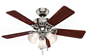 É um ventilador de teto clássico. Possui um corpo central de metal prateado (aço escovado ou cromo). Quatro pás largas de madeira escura (tom mogno ou cerejeira) estão fixadas ao corpo. Na parte inferior, há um kit de luz com três luminárias em forma de sino, com difusores de vidro fosco branco-leitoso. Duas correntes pendentes controlam a luz e a velocidade do ventilador.